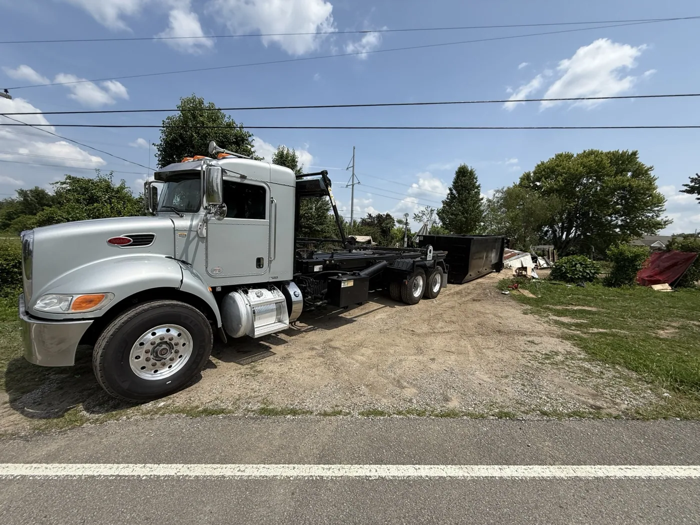 TriStar roll-off truck carrying a dumpster